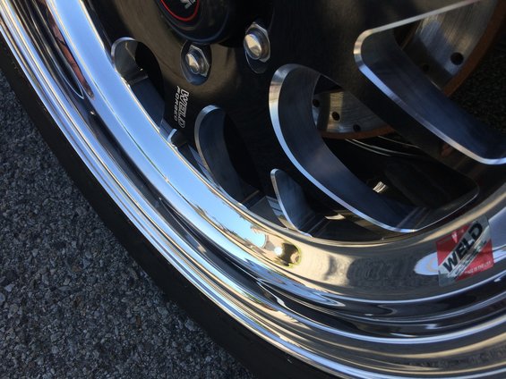 Close-up of a shiny Weld Racing wheel with a sticker on it
