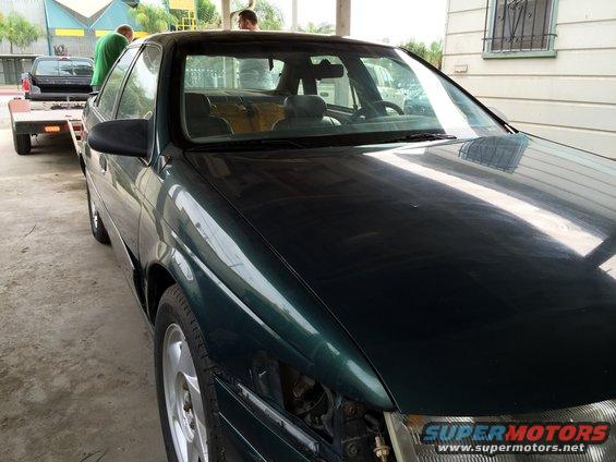 1993 Ford Taurus, dark green, 3/4 front view, being towed