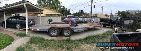 Dark 1993 Ford Taurus on trailer, side view