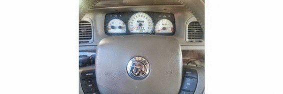 Interior dashboard of a 2000 Mercury Grand Marquis showing gauges and steering wheel emblem