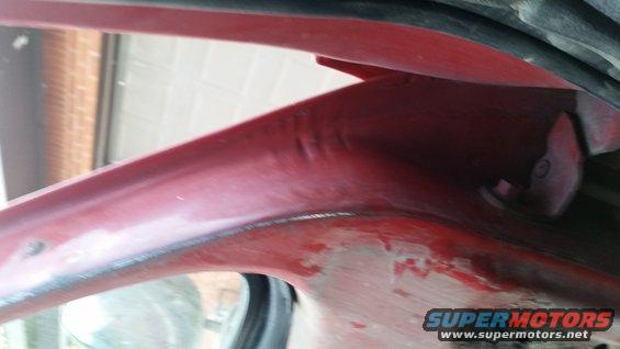 Red painted interior car panel with visible seams and a bolt head