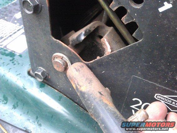 Close-up of rusty lever mechanism on green machine. Visible text: BRIGGS & Stratton