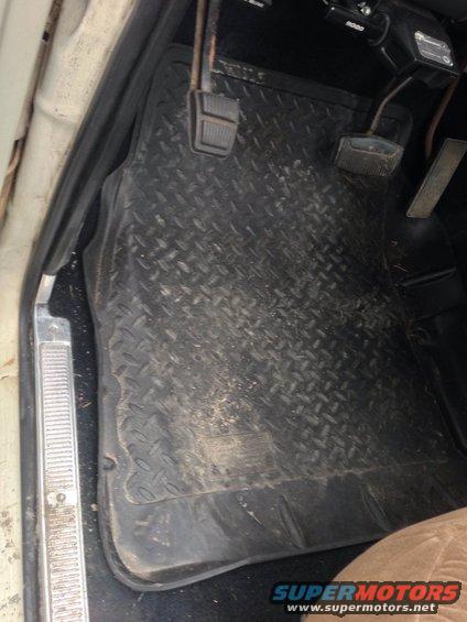 Close-up of diamond plate floor mats and pedals inside a vehicle