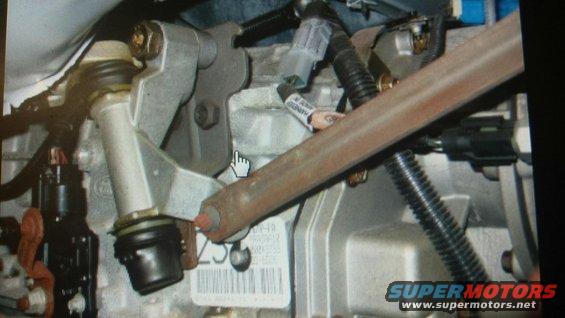 Close-up of engine parts with a metal rod and wiring harnesses
