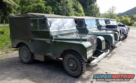 Green vintage Land Rover in a line, front 3/4 view