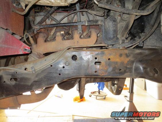 Engine and rusty frame components of a vehicle, viewed from below