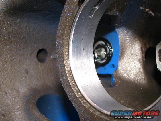 Close-up of an engine's bearing housing with blue paint and a bolt visible