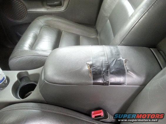 Gray interior center console armrest with duct tape repair