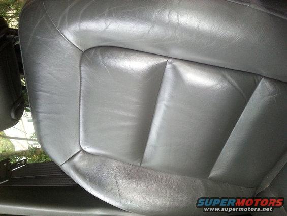 Gray leather car seat with visible stitching and some wear