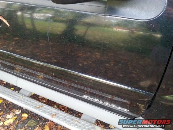 Dark SUV door trim with 'EXPLORER' badge and silver running board