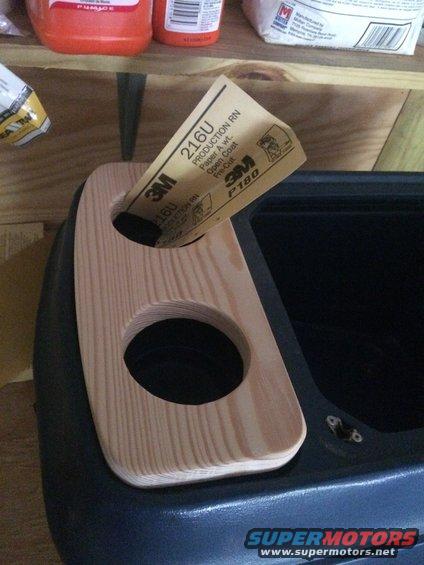 I cut this piece by using a paper template to fit in the groove of the cupholders.  Cut it a little large.  Sand it a lot.   Then sand it some more.  I used a 3" keyhole saw to make the cup openings.   