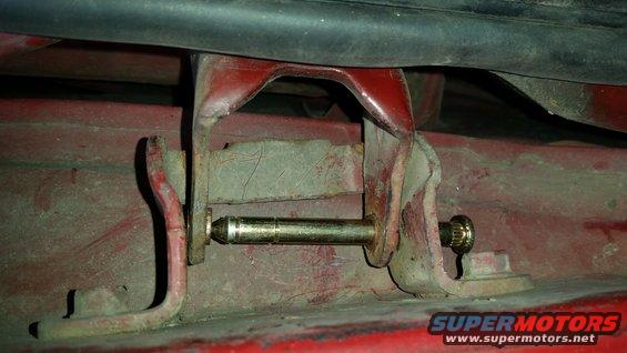Initially, I put in one of the new pins into only one hole.  This allowed the door to stay in place but also tip and move enough to where I could access the other hinge.  However, I found that the torque on a single pin would crack the new bushings.  I don't recommend it.