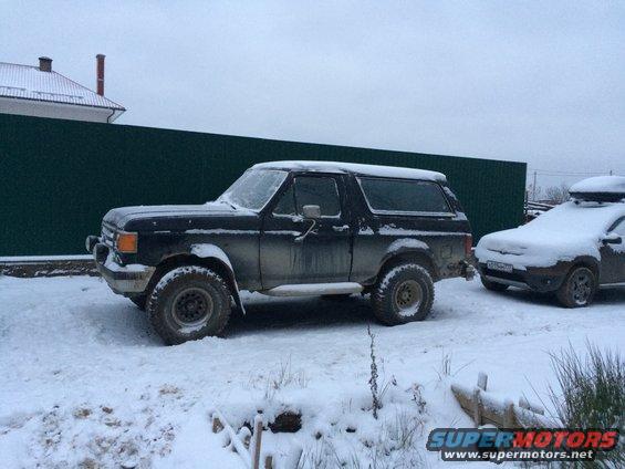 1987 Ford Bronco parked in snow next to another vehicle