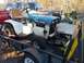 1982 Kubota RTV900 - A John Deere tractor is loaded onto a trailer, with other vehicles visible in the background.