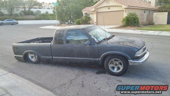 Dark gray pickup truck with a lowered suspension, seen from the front-three-quarter view