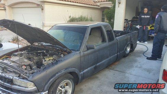 1996 Chevrolet S10 pickup truck, matte black paint, hood open showing engine, parked in driveway