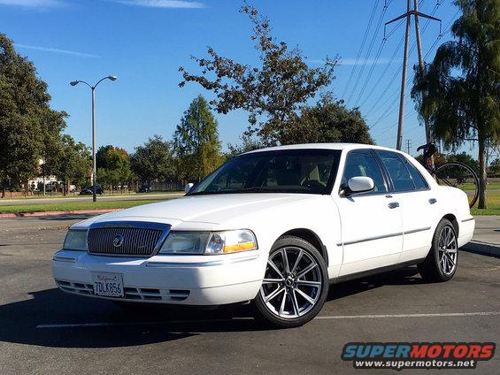 White sedan with custom wheels parked outdoors