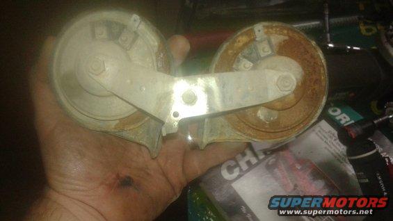 Dual horn assembly held in hand, showing rust