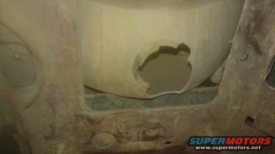 Undercarriage of a vehicle with a large hole in the wheel well liner