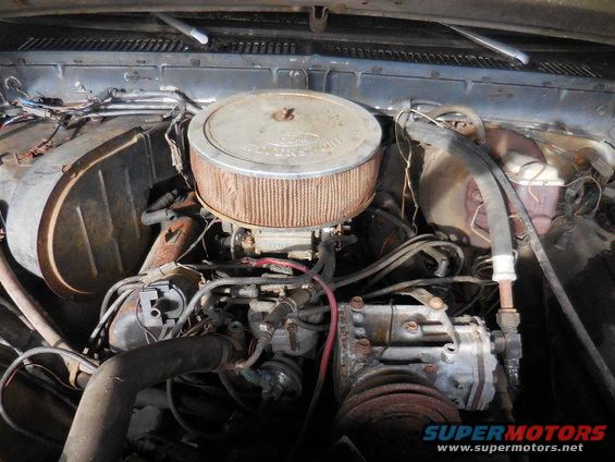 engine bay with air cleaner, carburetor, and hoses visible