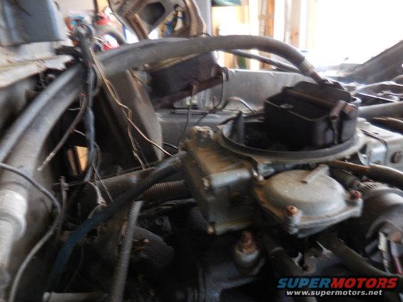 Engine bay close-up showing carburetor and brake fluid reservoir