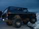 1978 Ford Bronco - A black Ford Bronco is parked on a snowy surface under a dark sky.