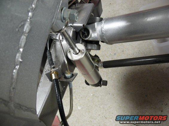 Close-up of a silver shock absorber and suspension linkage
