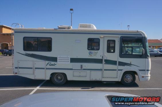 White motorhome with green stripe and 'Flair' text, parked in a lot