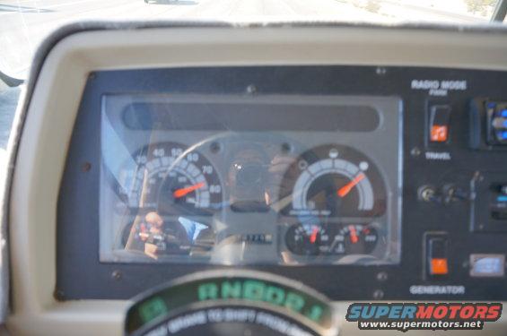 Dashboard gauges with red needles and white markings, including a speedometer and tachometer