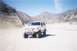 1988 Ford Bronco - A white Ford Bronco is parked in a dry, dusty landscape with mountains in the background.