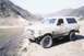 1988 Ford Bronco - A white Ford Bronco is parked on a dirt road in a mountainous area.