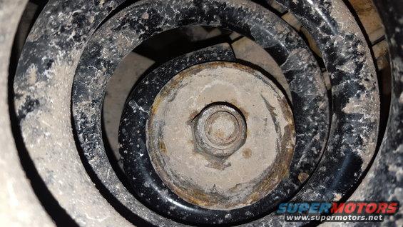 Close-up of a vehicle's suspension coil spring with a bolt visible