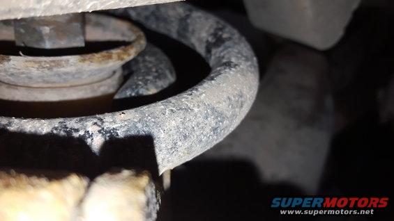 Close-up of a rusty suspension spring and bolt