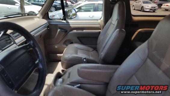 Interior of a 1995 Ford Bronco showing tan leather seats, dashboard, and steering wheel