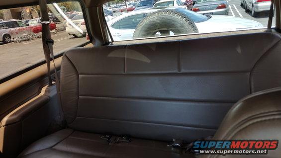 Brown leather seats inside a vehicle, spare tire visible outside
