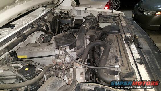 Engine bay of a 1995 Ford Bronco showing the V8 engine, radiator, and air intake system