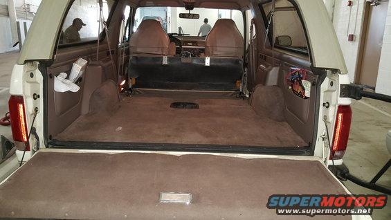 Tan interior of a 1992 Ford Bronco with the tailgate open, showing the cargo area and front seats
