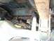 1979 Ford Bronco - The underside of the vehicle reveals significant rust and the complex exhaust system.