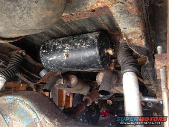 Underbody view of vehicle showing air tank, exhaust pipes, and suspension components