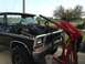 1979 Ford Bronco - Man uses engine hoist to remove the engine from a black 1979 Ford Bronco.
