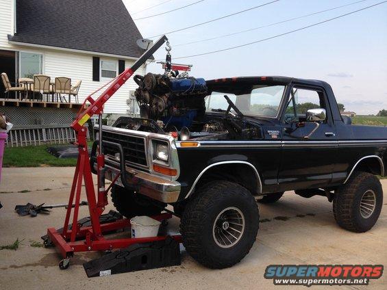 Black 1978 Ford Bronco with engine hoist lifting out the engine
