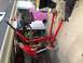 1979 Ford Bronco - An engine is being lifted out of a vehicle using a red engine hoist in a garage setting.