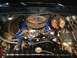 1979 Ford Bronco - Close-up view of a vehicle's engine bay, a blue intake manifold and a chrome air cleaner assembly.