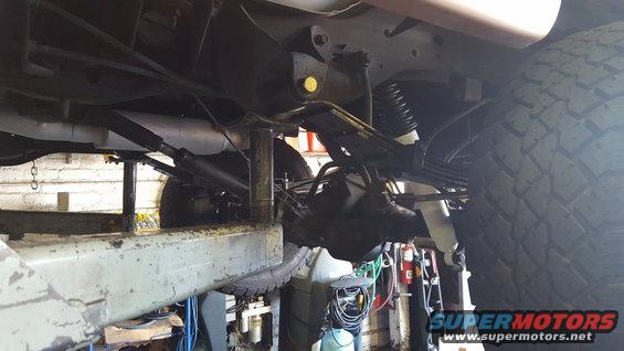 Underside view of a vehicle's rear axle, leaf springs, and shock absorbers