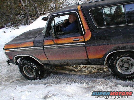 Ford Bronco driving in snow, driver visible inside