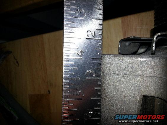 Ruler next to a metal component, showing measurements up to 4 inches