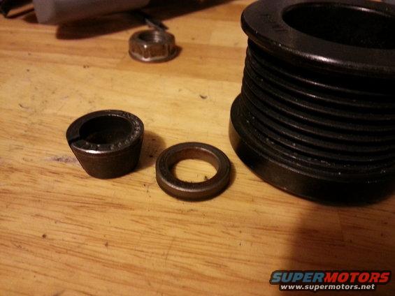 Pulley, bearing, and nut on wooden surface