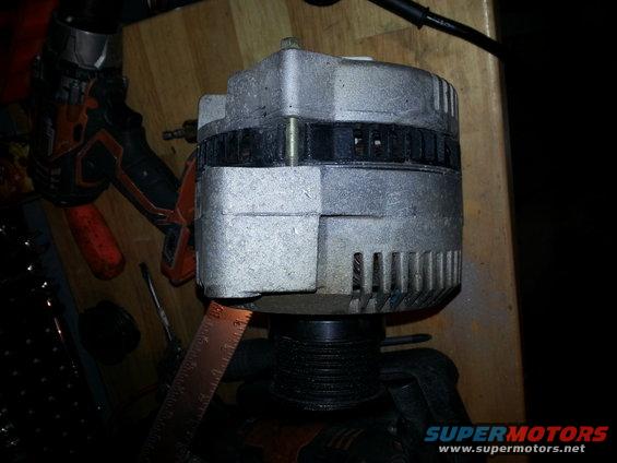 close-up of an alternator with a ruler next to it