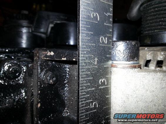 Ruler measuring bolt head on an alternator