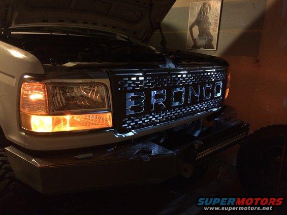 Bronco grille with illuminated letters on a white truck, front view